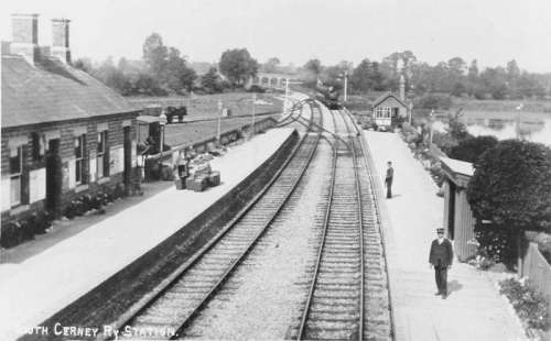 Station staff look towards the camera as a south-bound service approaches